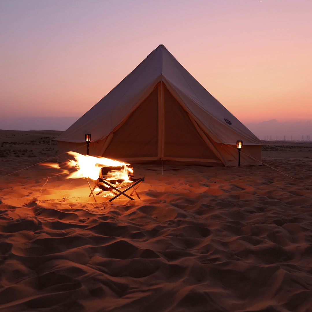 The Bedouin bell tent at dusk with a campfire burning in front