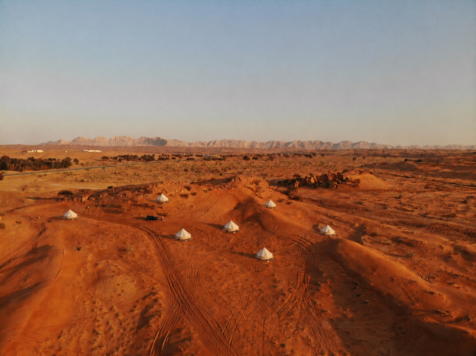 Aerial view of a desert glamping camp with bell tents
